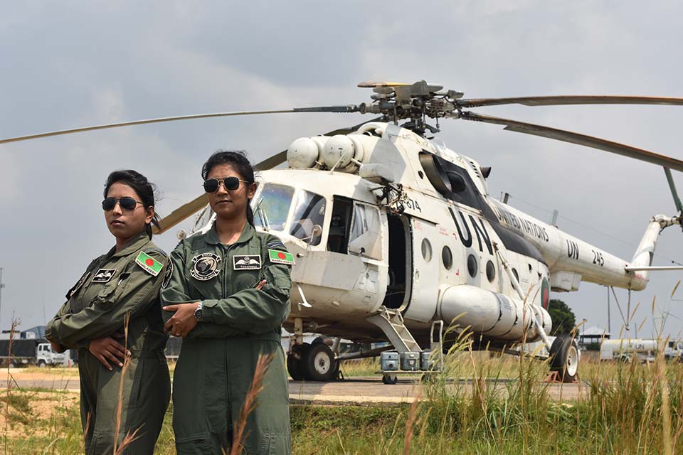 Deployed women pilots from Bangladesh pose in front of helicopter